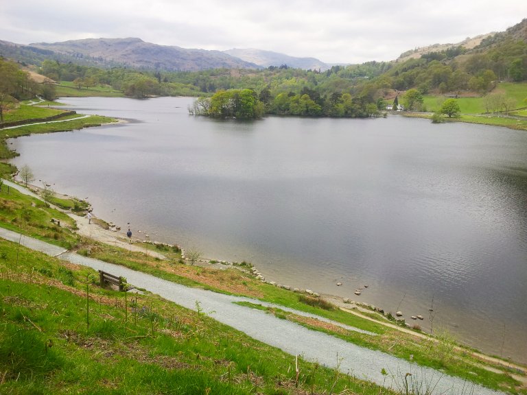 Far below us as we walked, we saw beautiful Rydal Water. From our vantage point we can see almost the whole lake, not much more than a kilometre long and quite narrow. Below us a footpath runs alongside the lake, and we can see two men, tiny at this distance, standing on the shoreline. Beyond the lake, out of sight to us here, lies Grasmere, and in the distance, the mountains.