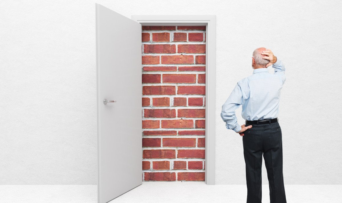 An illustration showing an open door, but the exit is bricked up. An elderly man has approached the door and is wondering how to get out.