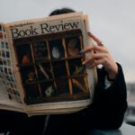 A woman reading a newspaper called 'Book Review'